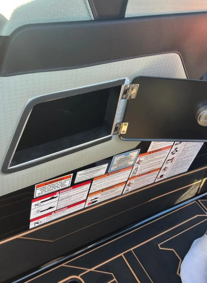 Slide: The Image of 2025 Centurion Ri 265 interior storage compartment with open door and safety labels. - 39