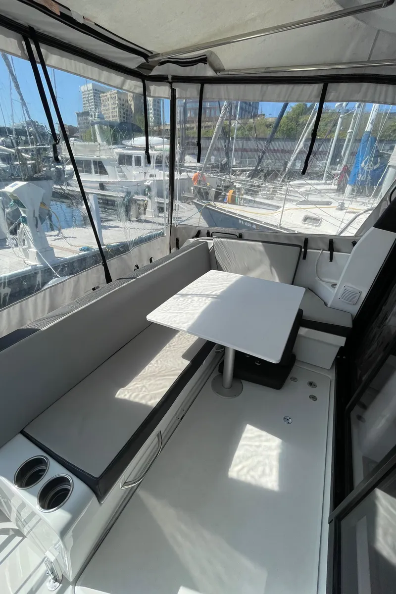 Slide: The Image of 2019 Jeanneau NC895 boat interior with seating and table, docked at marina. - 12
