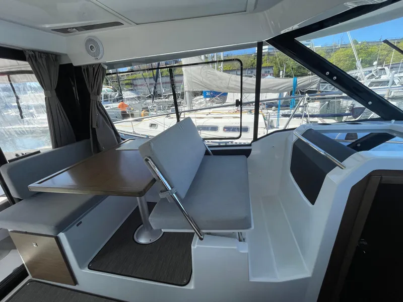 Slide: The Image of Interior of 2019 Jeanneau NC895 boat with seating and table, docked at marina. - 16