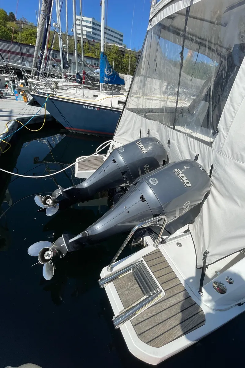 Slide: The Image of 2019 Jeanneau NC895 with dual outboard motors docked at a marina. - 3
