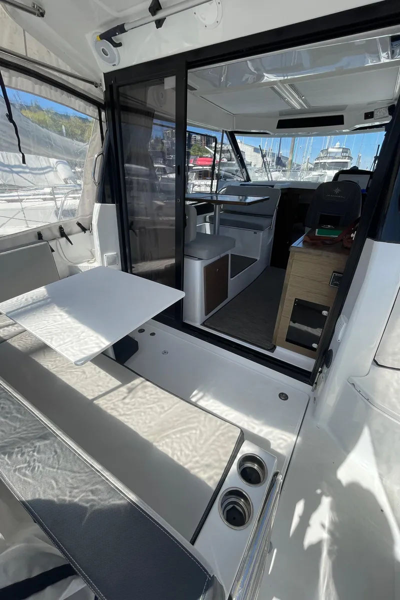 Slide: The Image of 2019 Jeanneau NC895 interior with seating, table, and helm, showcasing modern design and functionality. - 4