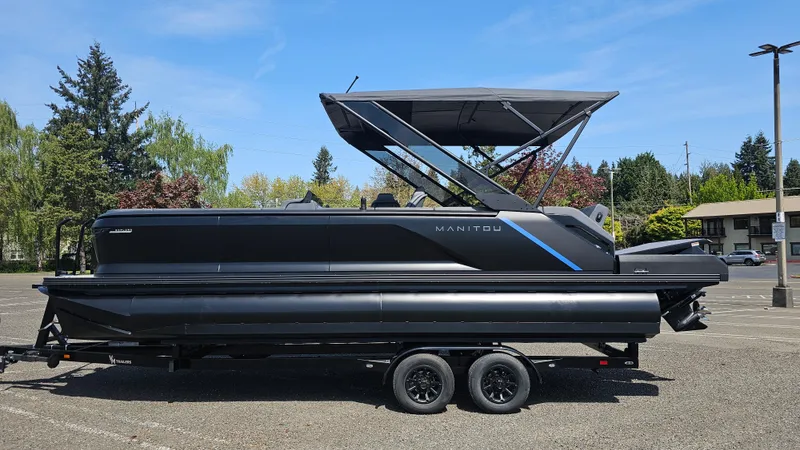 The Image of 2025 Manitou 24' Explore MAX Deck Navigator with 150hp Rotax Stealth Motor, parked outdoors. - 0