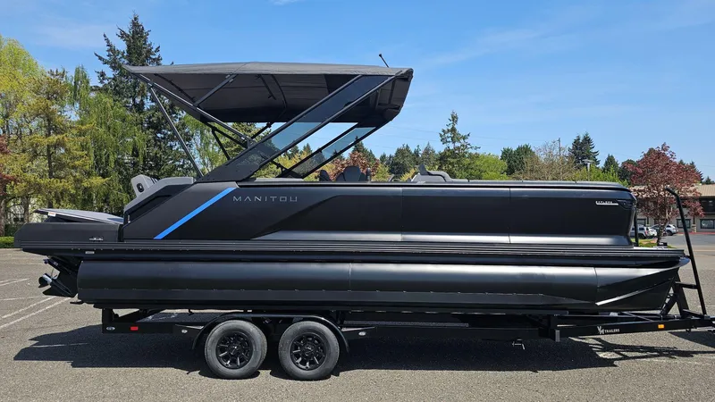 Slide: The Image of 2025 Manitou 24' Explore MAX Deck Navigator with 150hp Rotax Stealth Motor on trailer. - 1
