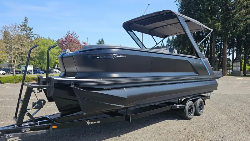 Slide: The Image of 2025 Manitou 24' Explore MAX Deck Navigator with 150hp Rotax Stealth Motor on trailer. - 2