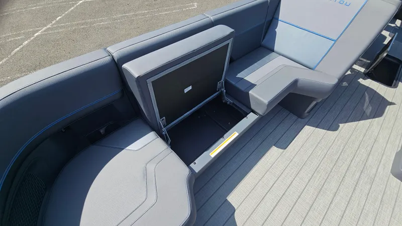 Slide: The Image of 2025 Manitou 24' Explore MAX Deck Navigator with open storage compartment and sleek seating. - 35