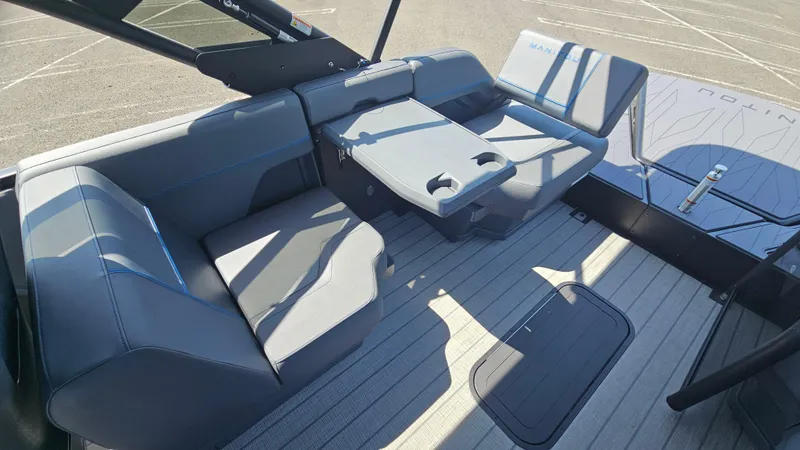 Slide: The Image of 2025 Manitou 24' Explore MAX Deck Navigator interior with sleek seating and table. - 43