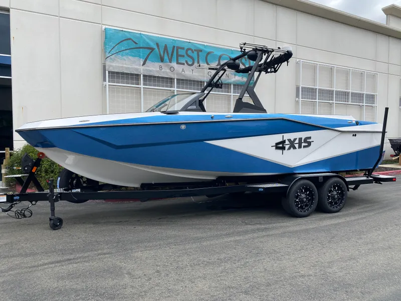 Slide: The Image of 2025 Axis T250 boat in blue and white on a trailer outside West Coast dealership. - 14