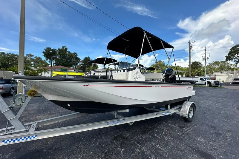 Slide: The Image of 2022 Boston Whaler 170 Montauk boat on trailer, parked outdoors under blue sky. - 1