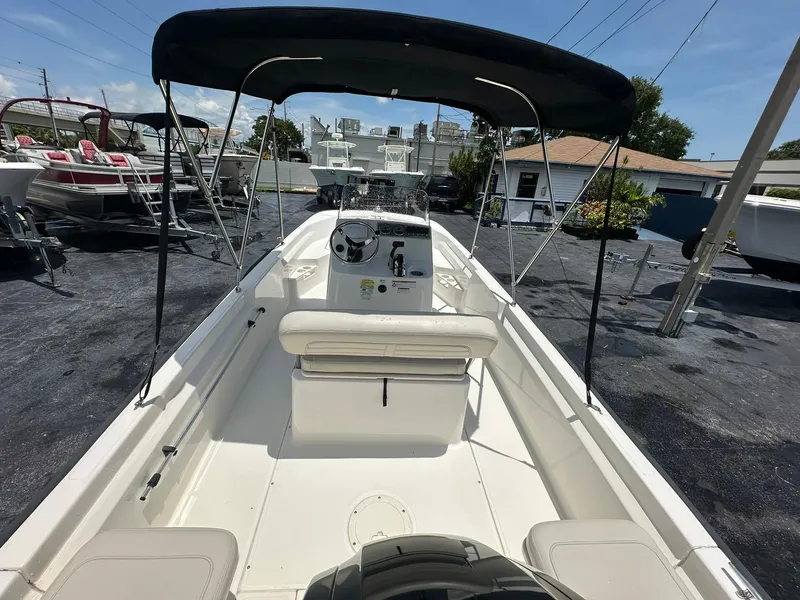 Slide: The Image of 2022 Boston Whaler 170 Montauk boat with canopy, parked in a marina. - 9