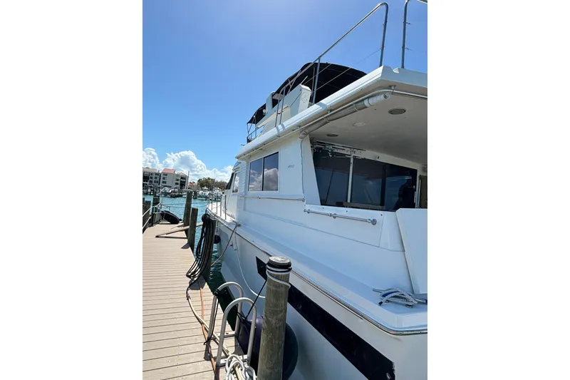 Slide: The Image of 1990 Viking Extended Aft Deck Motor Yacht docked under clear blue sky. - 25