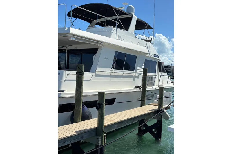 Slide: The Image of 1990 Viking Extended Aft Deck Motor Yacht docked at marina under clear sky. - 28