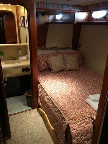Slide: The Image of Cozy bedroom in 1990 Viking Extended Aft Deck Motor Yacht with patterned bedding and ensuite bathroom. - 14