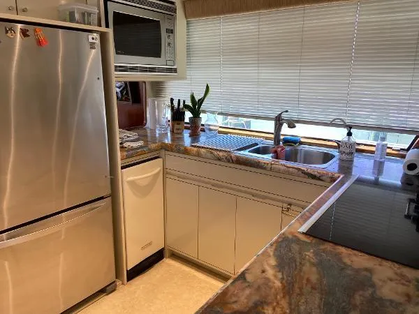 Slide: The Image of Kitchen interior of 1990 Viking Extended Aft Deck Motor Yacht with modern appliances and marble countertops. - 9