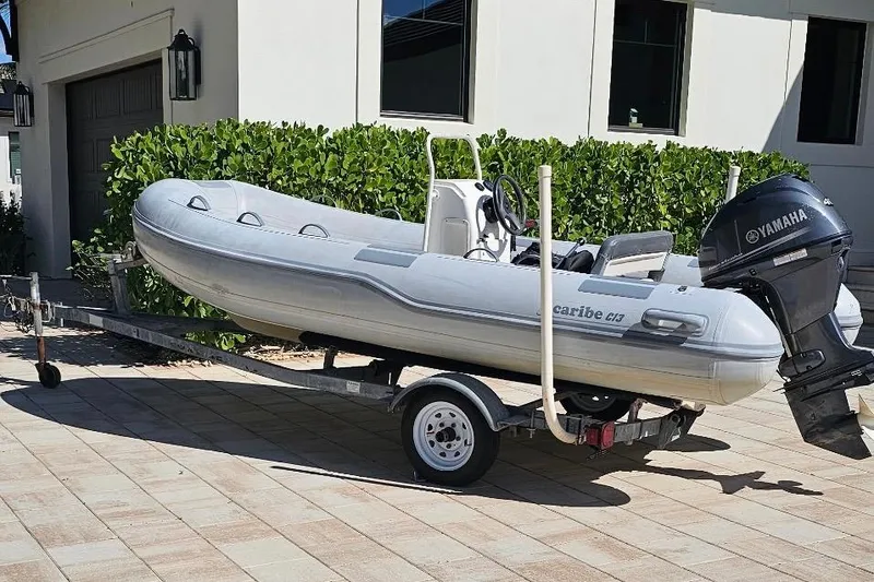 Slide: The Image of Inflatable boat with Yamaha motor on a trailer in front of a house. - 29