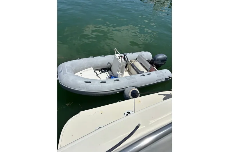Slide: The Image of Inflatable dinghy beside 1990 Viking Extended Aft Deck Motor Yacht on calm water. - 30