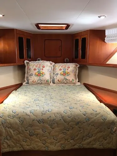 Slide: The Image of Cozy bedroom in 1990 Viking Extended Aft Deck Motor Yacht with floral bedding and wooden cabinets. - 15