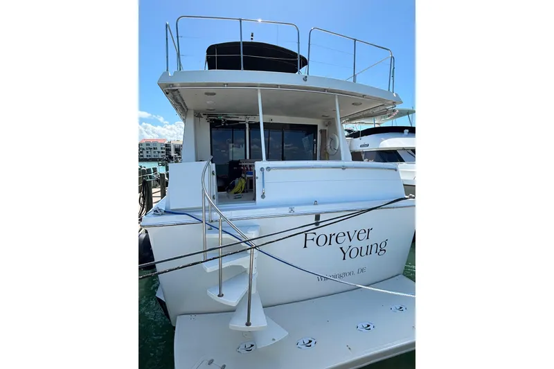 Slide: The Image of 1990 Viking Extended Aft Deck Motor Yacht docked, named "Forever Young," with spiral staircase. - 26