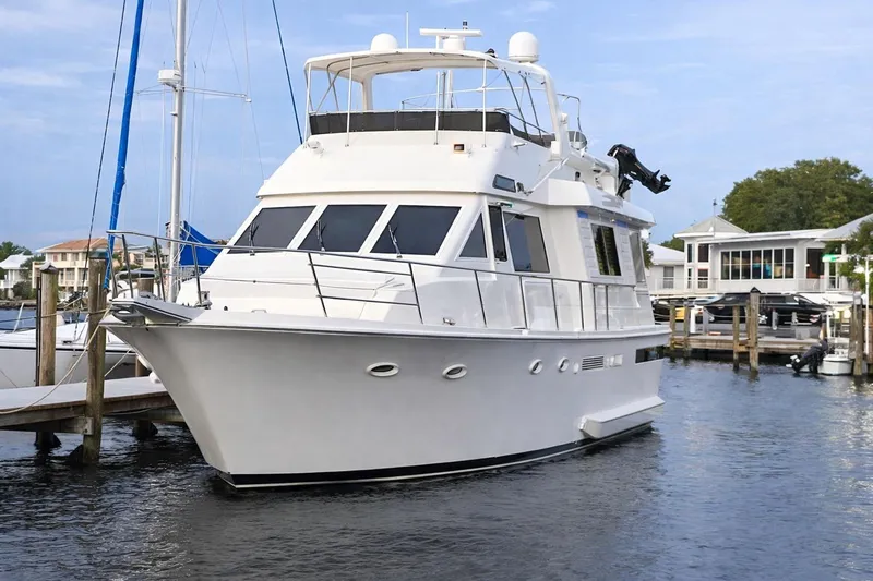 Slide: The Image of 1990 Viking Extended Aft Deck Motor Yacht docked in a marina, showcasing sleek design. - 2