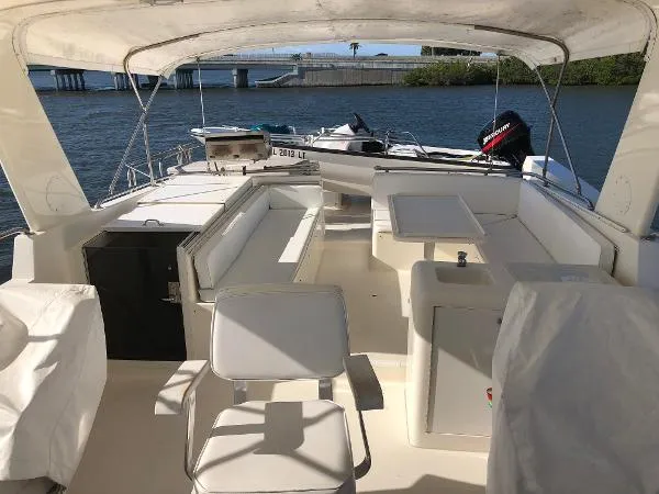 Slide: The Image of 1990 Viking Extended Aft Deck Motor Yacht with spacious seating and table on a sunny day. - 3