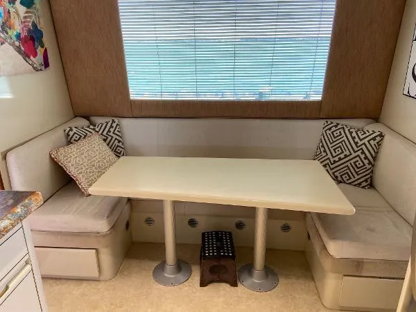 Slide: The Image of Cozy dining nook in 1990 Viking Extended Aft Deck Motor Yacht with cushioned seating and table. - 11
