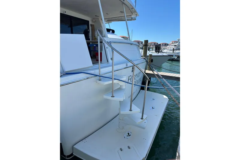 Slide: The Image of 1990 Viking Extended Aft Deck Motor Yacht docked, featuring spiral staircase and marina view. - 27