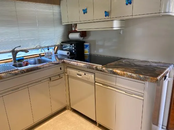 Slide: The Image of Kitchen area of 1990 Viking Extended Aft Deck Motor Yacht with marble countertops and butterfly accents. - 10