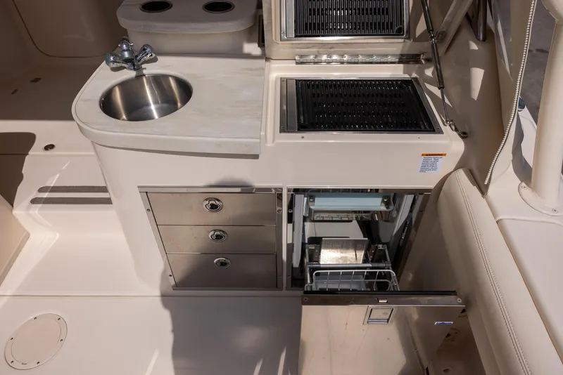 Slide: The Image of 2018 Grady-White Freedom 335 boat kitchen with sink, grill, and storage drawers. - 10