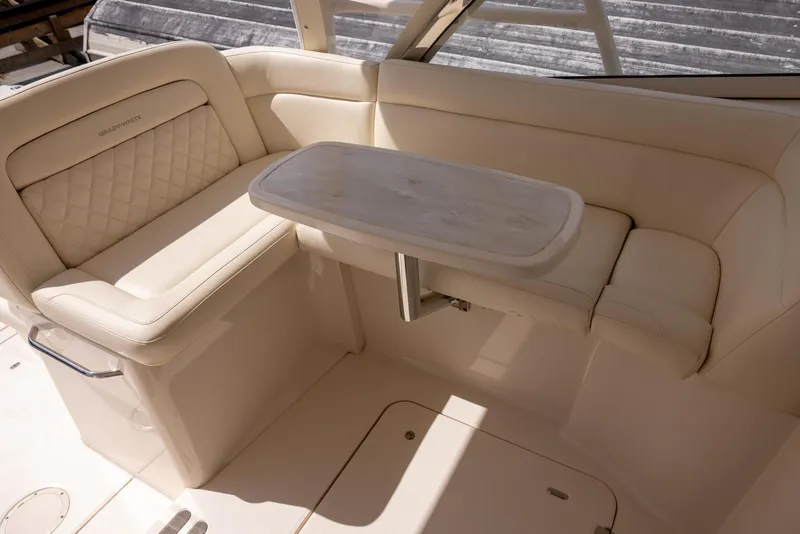 Slide: The Image of 2018 Grady-White Freedom 335 boat interior with beige seating and a small table. - 15