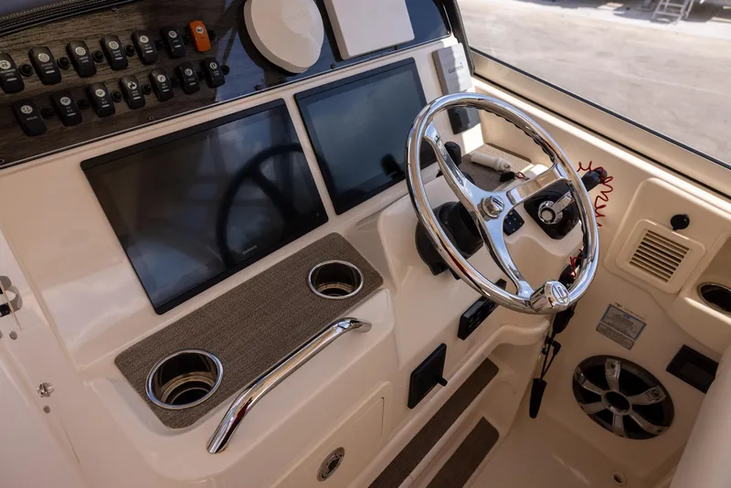 Slide: The Image of 2018 Grady-White Freedom 335 boat dashboard with steering wheel and dual screens. - 17