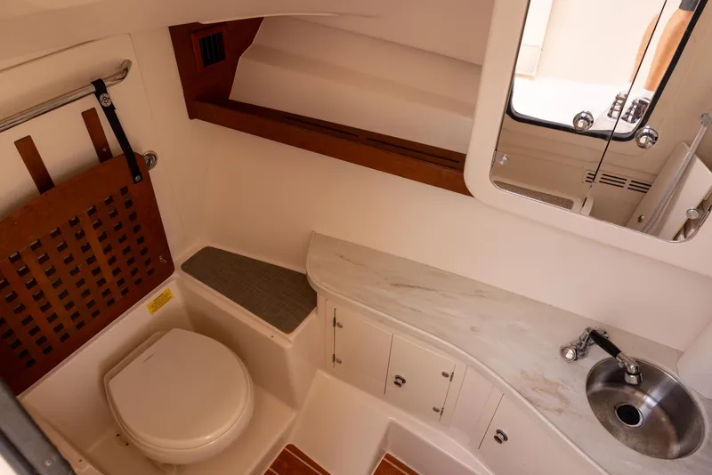 Slide: The Image of 2018 Grady-White Freedom 335 boat interior with toilet, sink, and storage cabinets. - 19