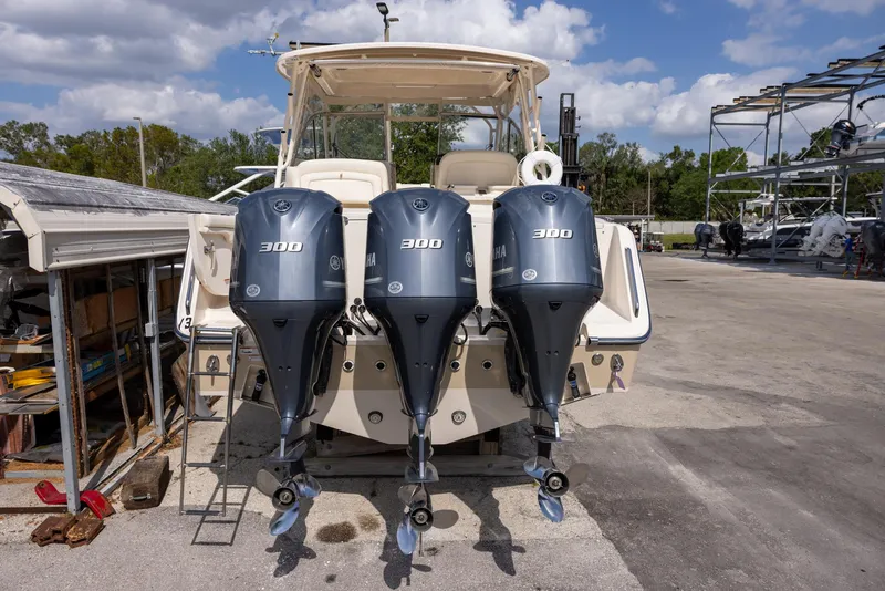 Slide: The Image of 2018 Grady-White Freedom 335 boat with triple 300 horsepower engines, parked outdoors. - 4