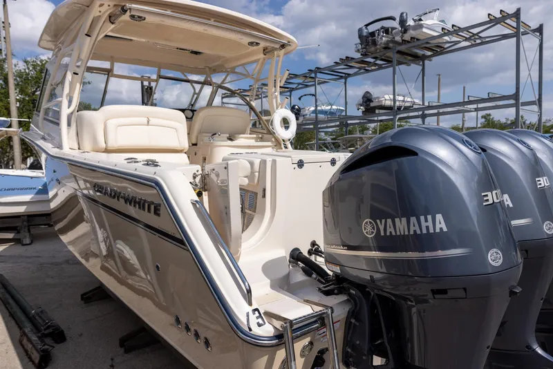 Slide: The Image of 2018 Grady-White Freedom 335 boat with Yamaha engines, docked under a blue sky. - 5