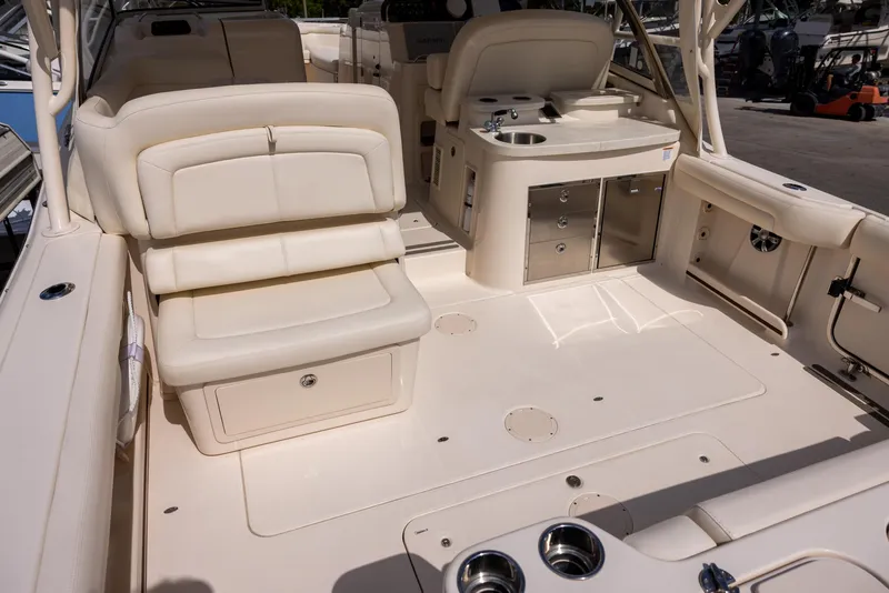 Slide: The Image of 2018 Grady-White Freedom 335 boat interior with beige seating and storage compartments. - 6