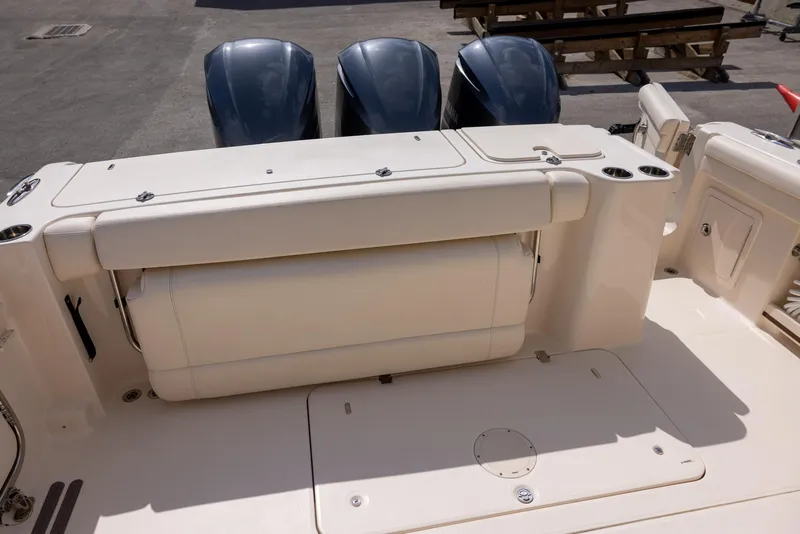 Slide: The Image of 2018 Grady-White Freedom 335 boat with triple outboard engines, featuring a spacious deck layout. - 7
