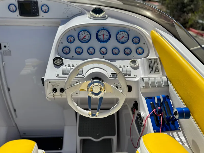 Slide: The Image of 2004 Donzi 38 ZX boat dashboard with white steering wheel and yellow accents. - 24