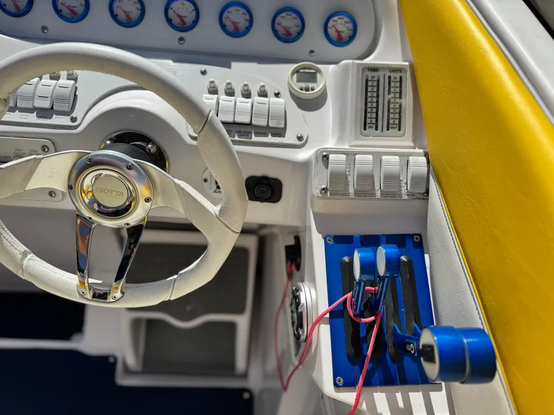 Slide: The Image of 2004 Donzi 38 ZX boat cockpit with steering wheel and control panel. - 25