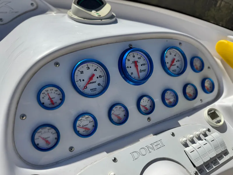 Slide: The Image of Dashboard of a 2004 Donzi 38 ZX boat with multiple gauges and controls. - 27