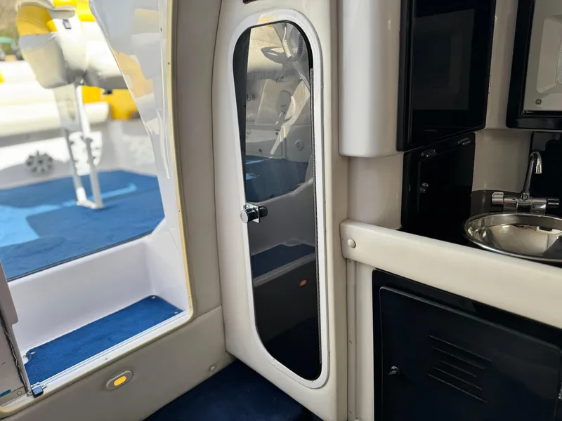 Slide: The Image of Interior view of a 2004 Donzi 38 ZX boat, featuring a sleek cabin door and compact kitchenette. - 57