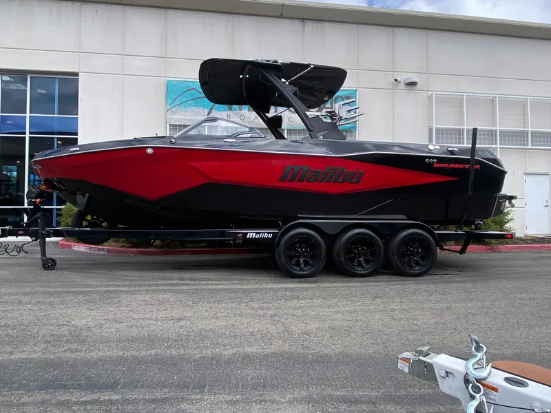 The Image of 2025 Malibu Wakesetter 25 LSV boat in red and black on a trailer. - 0