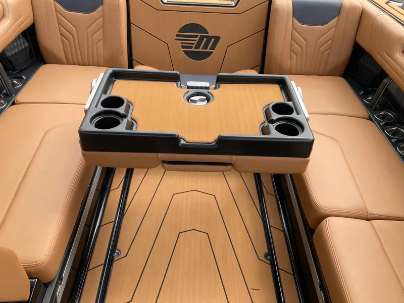 Slide: The Image of 2025 Malibu Wakesetter 25 LSV interior with tan seating and a central table with cup holders. - 17