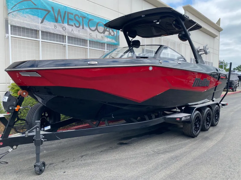 Slide: The Image of 2025 Malibu Wakesetter 25 LSV boat in red and black on a trailer at West Coast Boat Center. - 2