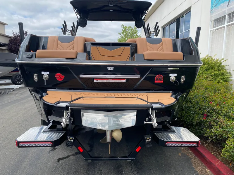 Slide: The Image of 2025 Malibu Wakesetter 25 LSV boat rear view with tan seating and black exterior. - 5