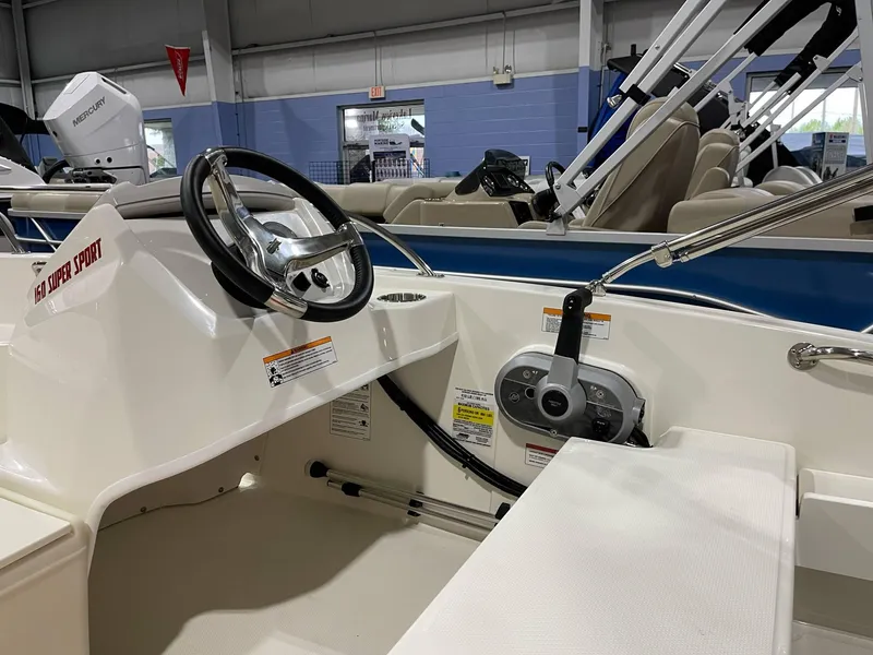 Slide: The Image of 2025 Boston Whaler 160 Super Sport boat interior with steering wheel and control panel. - 9