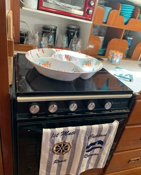 Slide: The Image of 1985 Roughwater 36 kitchen with stove, colorful dishes, and nautical-themed towel. - 10