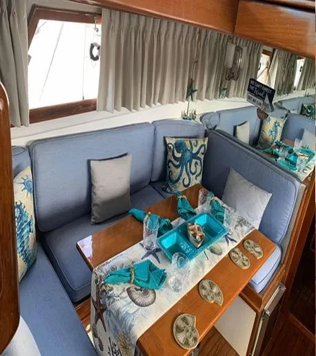 Slide: The Image of 1985 Roughwater 36 yacht interior with nautical-themed decor and blue seating. - 11