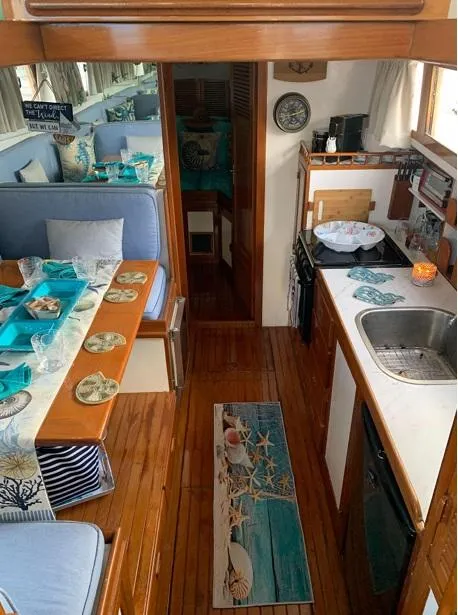 Slide: The Image of Interior of 1985 Roughwater 36 boat with cozy dining and kitchen area. - 12
