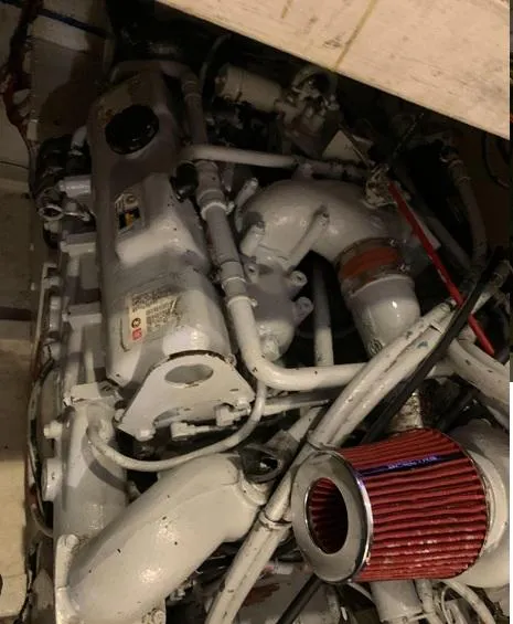 Slide: The Image of Engine compartment of a 1985 Roughwater 36 boat, featuring visible pipes and a red air filter. - 16