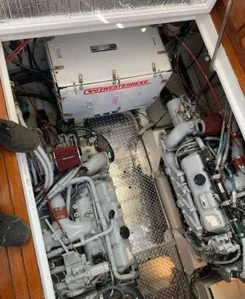 Slide: The Image of Engine room of a 1985 Roughwater 36 boat, featuring dual engines and a Westerbeke generator. - 19