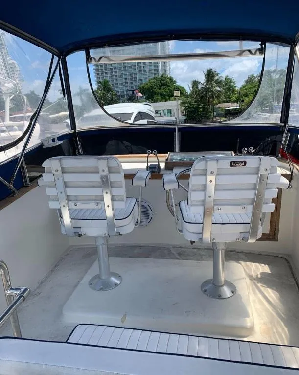 Slide: The Image of 1985 Roughwater 36 boat interior with two white captain chairs and a blue canopy. - 6