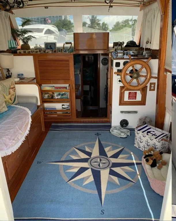 Slide: The Image of Interior of 1985 Roughwater 36 boat with nautical decor and compass-themed rug. - 7